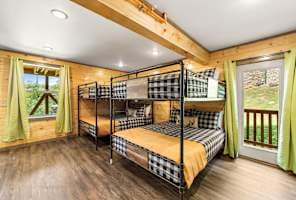 This spacious bunk room features two queen-over-queen bunk beds and connects to the game room, making it perfect for kids and groups. With rustic charm and modern comfort, it’s a fun and cozy space to relax after a day of adventure!