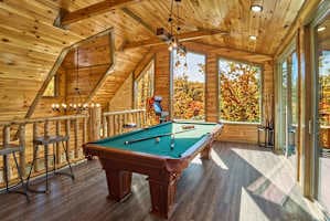 Unwind in the game room, where adults can enjoy a pool table while kids have fun on the arcade machine! This cozy cabin-style space is perfect for friendly competition, late-night games, and family entertainment.