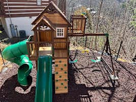 Exciting outdoor play area for kids! Featuring a wooden playhouse, swings, climbing wall, and thrilling slides. A perfect space for little ones to have fun while parents relax. Safe, family-friendly, and designed for adventure!