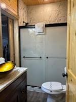 This full bathroom offers modern comfort with fresh towels, toilet paper, hand soap, body soap, and a hair dryer. Featuring a walk-in shower, granite vanity, and cozy cabin charm, it's stocked with essentials to ensure a refreshing & hassle-free stay