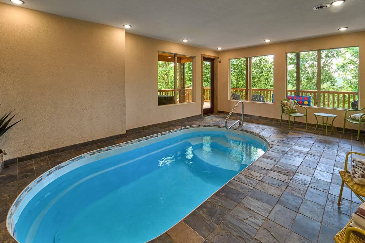 Enjoy a private, year-round heated indoor pool with 24/7 access! Perfect for families, couples, and groups, this space features a secure key door for child safety and scenic views. Relax in a climate-controlled oasis, ideal for any season.
