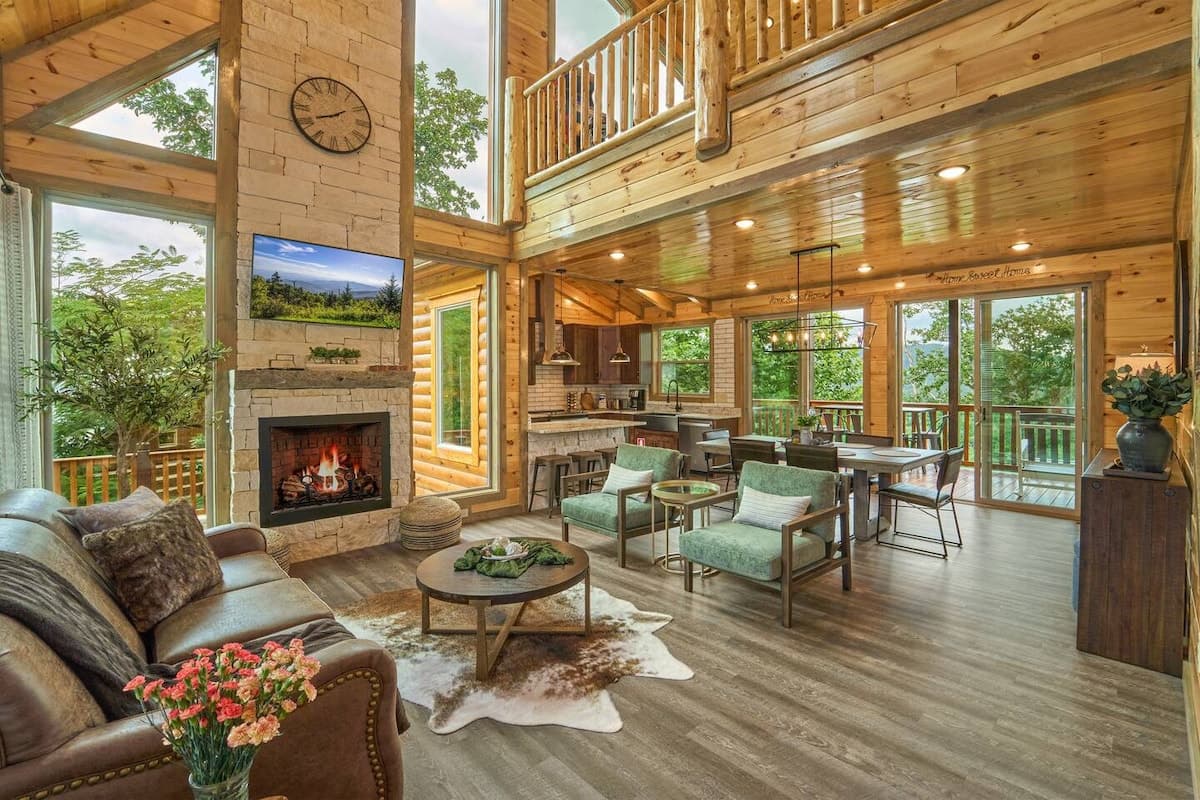 Step into this stunning cabin retreat with soaring ceilings, a cozy fireplace, and breathtaking mountain views. Enjoy an open-concept living space with a fully equipped kitchen and plenty of natural light. The perfect getaway just minutes from top at