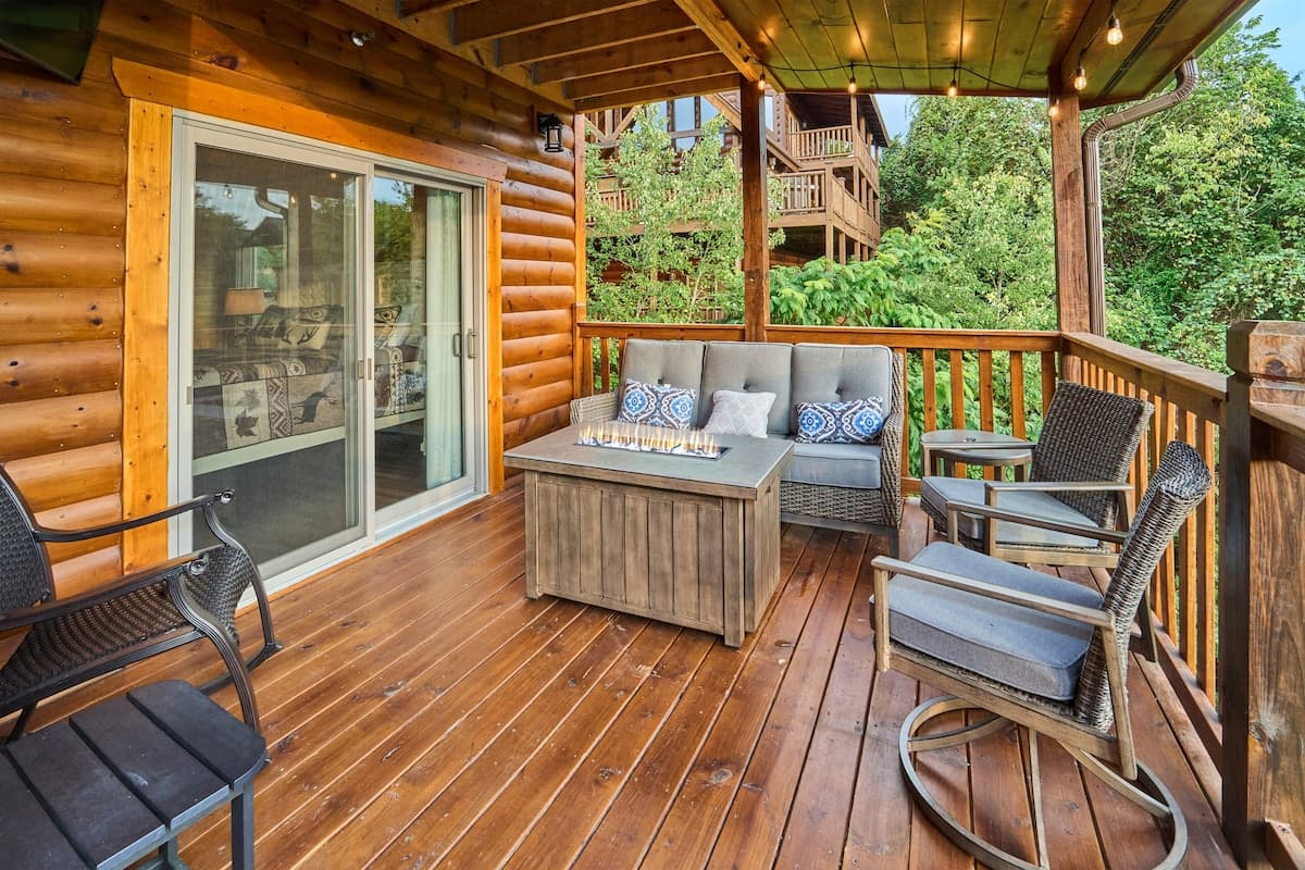 Relax on the covered deck with a comfortable outdoor sofa, rocking chairs, and a fire table for cozy evenings. Perfect for morning coffee or unwinding under the string lights, this inviting space offers the ultimate cabin retreat experience!