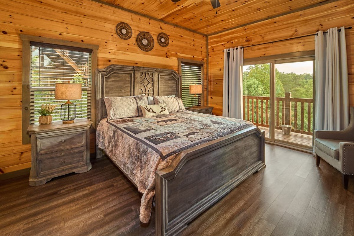 Unwind in this cozy king-size bedroom with a dresser, TV, closet, and private full bathroom. Step onto the balcony with seating to enjoy peaceful nature views. Designed for comfort and relaxation, this rustic retreat is perfect for a restful stay!