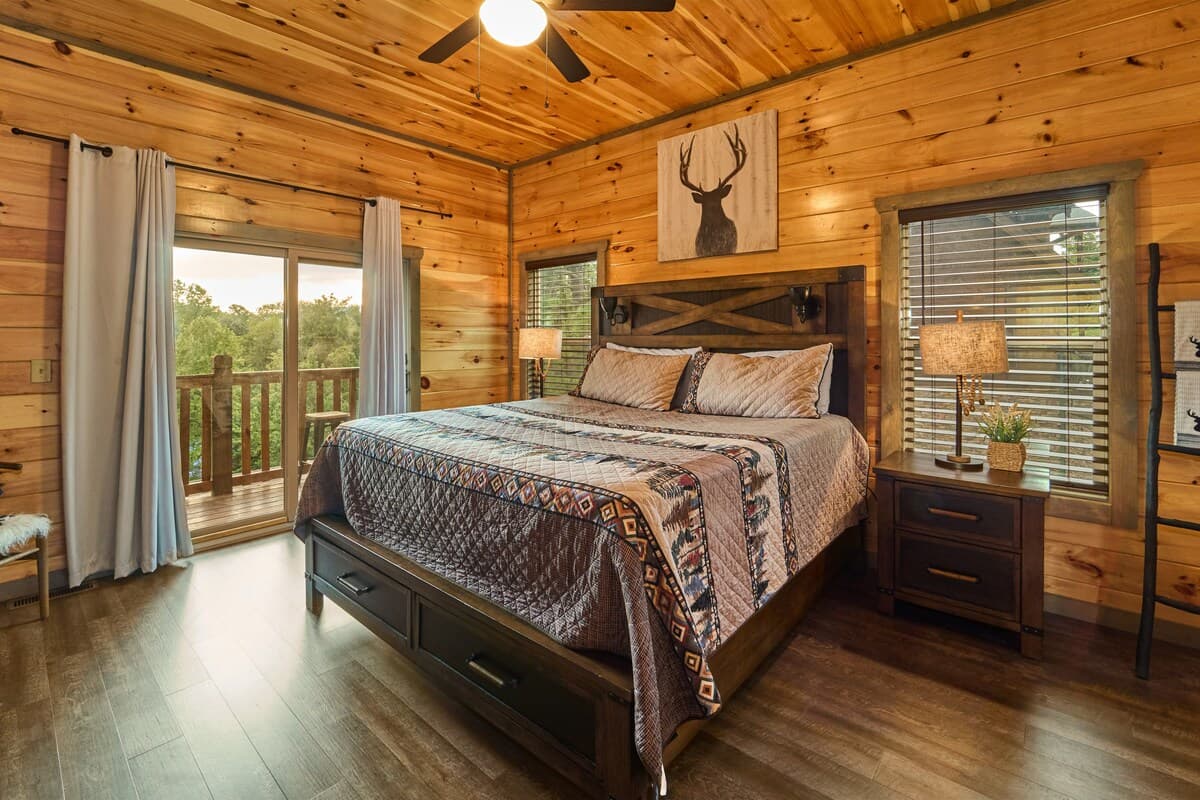 Unwind in this cozy king-size bedroom with a dresser, TV, closet, and private full bathroom. Step onto the balcony with seating to enjoy peaceful nature views. Designed for comfort and relaxation, this rustic retreat is perfect for a restful stay!