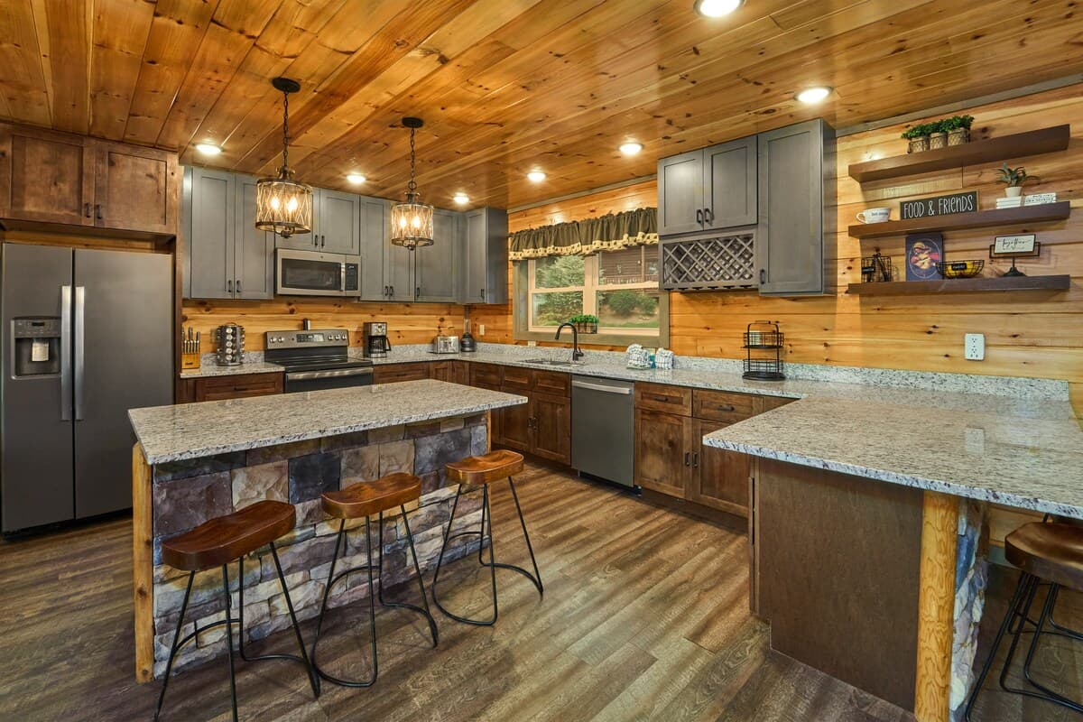 Cook with ease in this fully equipped kitchen, featuring modern appliances, granite countertops, and plenty of prep space. The island offers six extra seats, making it perfect for gathering, dining, or entertaining. A stylish blend of rustic charm!
