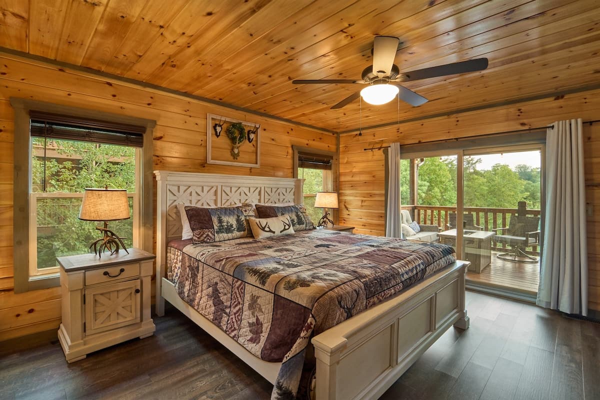 Unwind in this cozy king-size bedroom with a dresser, TV, closet, and private full bathroom. Step onto the deck with seating to enjoy peaceful nature views. Designed for comfort and relaxation, this rustic retreat is perfect for a restful stay!