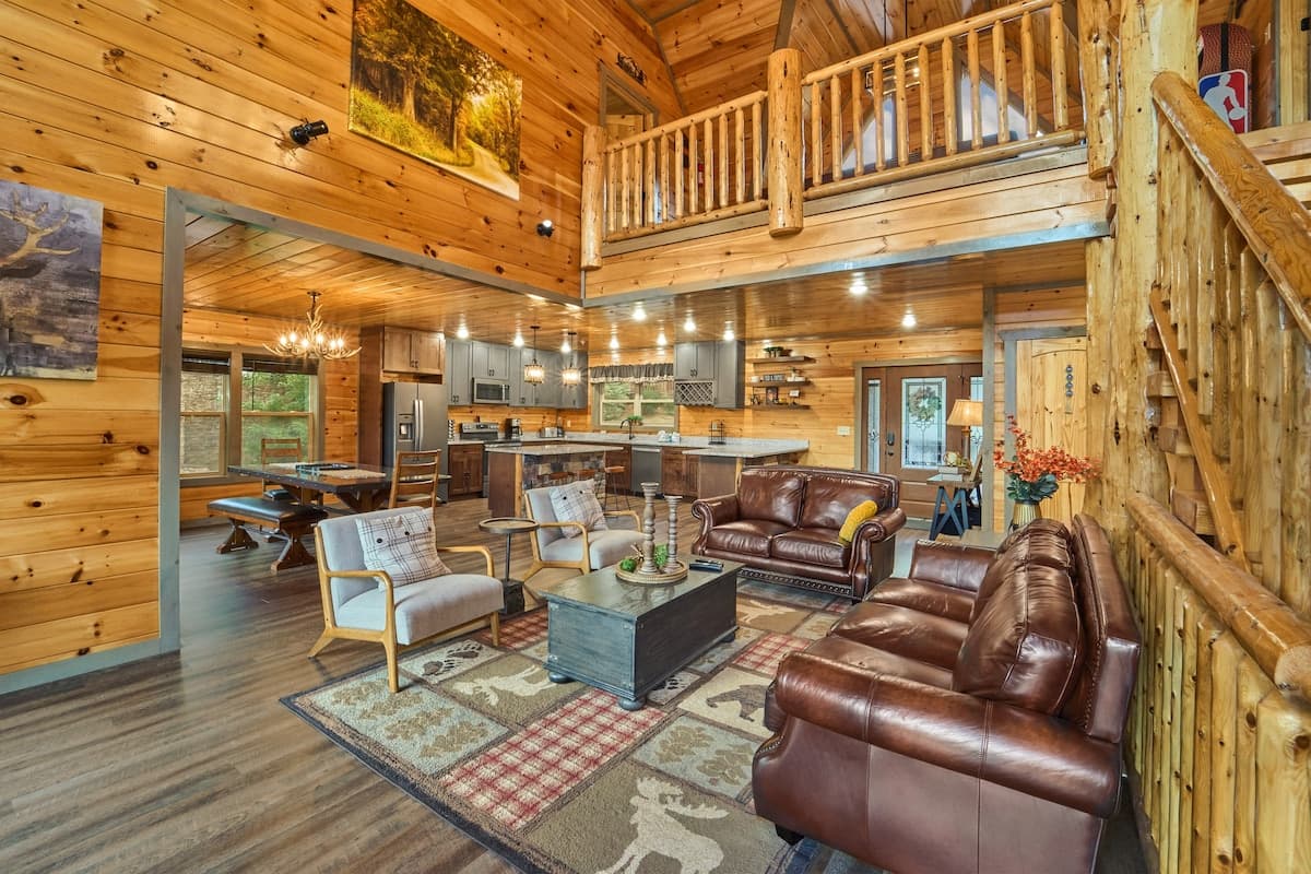 This stunning open-concept cabin features a spacious living room, fully equipped kitchen & dining area, all under soaring vaulted ceilings. Cozy leather seating, rustic charm & modern touches create the perfect space for gathering & making memories!