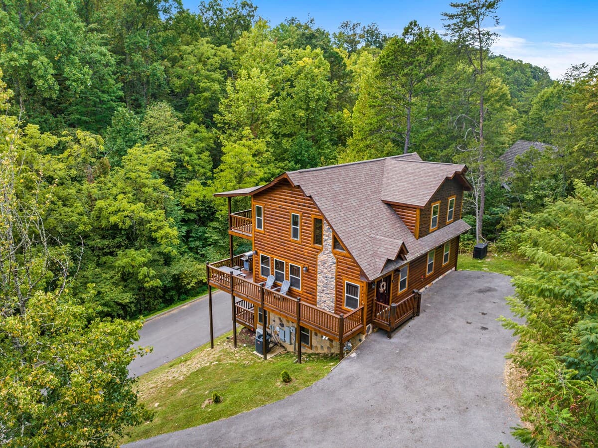 Nestled in the trees, this spacious log cabin offers a perfect blend of seclusion and convenience. Enjoy multiple decks, cozy outdoor seating, and private parking. Just minutes from Pigeon Forge attractions, it's the ideal mountain getaway!