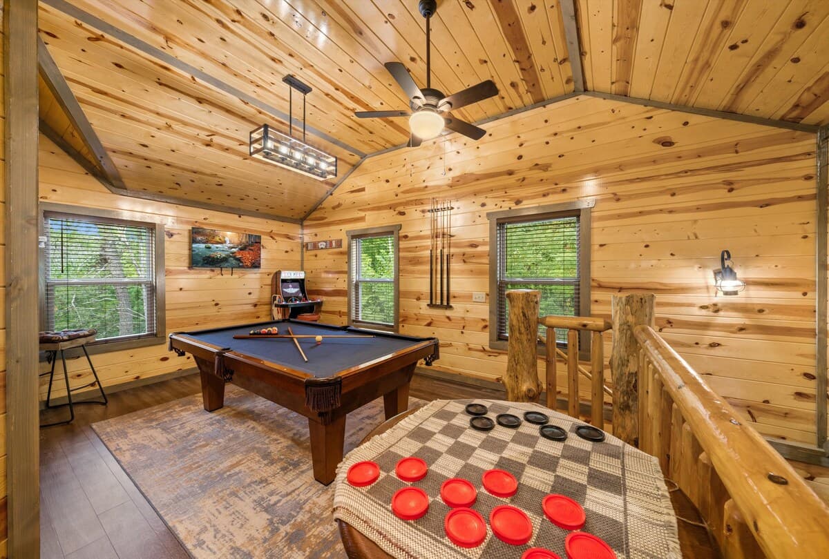 Unwind in the game room, where adults can enjoy a pool table while kids have fun on two arcade machines! This cozy cabin-style space is perfect for friendly competition, late-night games, and family entertainment.