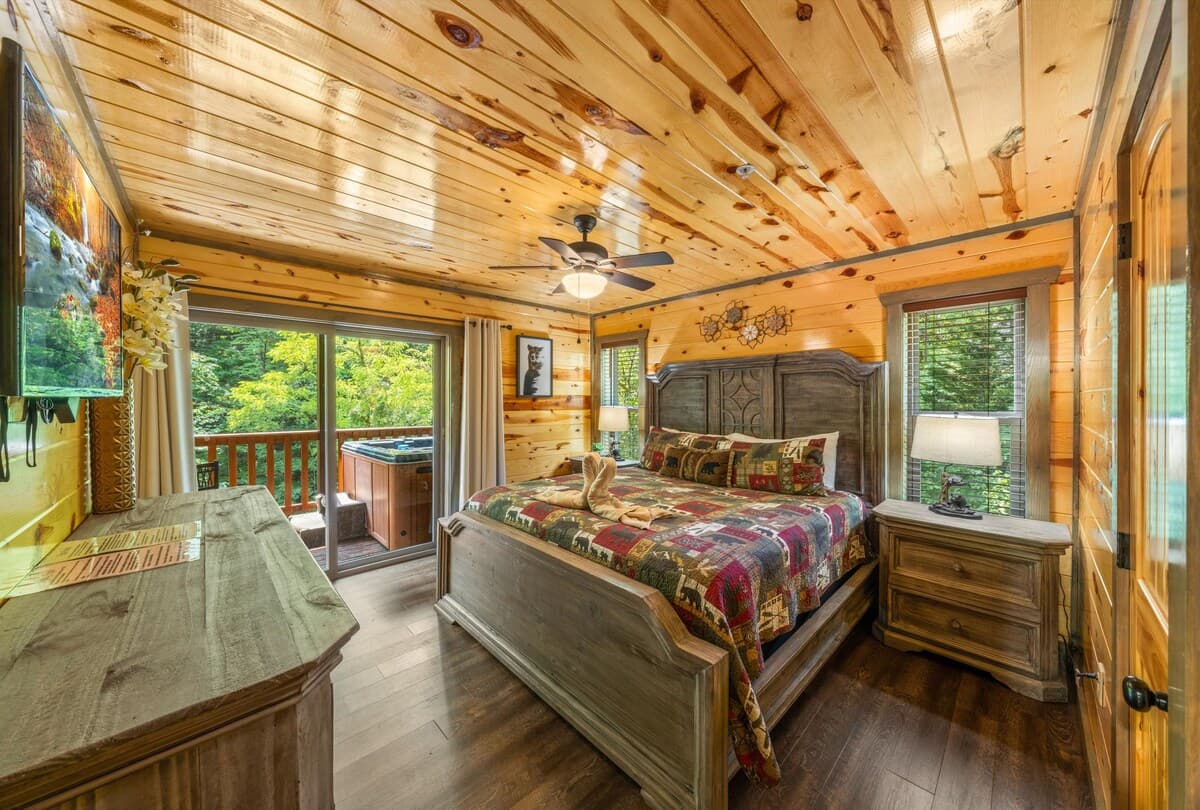 Relax in a spacious bedroom featuring a king-size bed, private bathroom, and closet. Step onto the deck for fresh air and nature views. With cozy cabin décor and modern amenities, this inviting retreat offers perfect blend of comfort and tranquility.