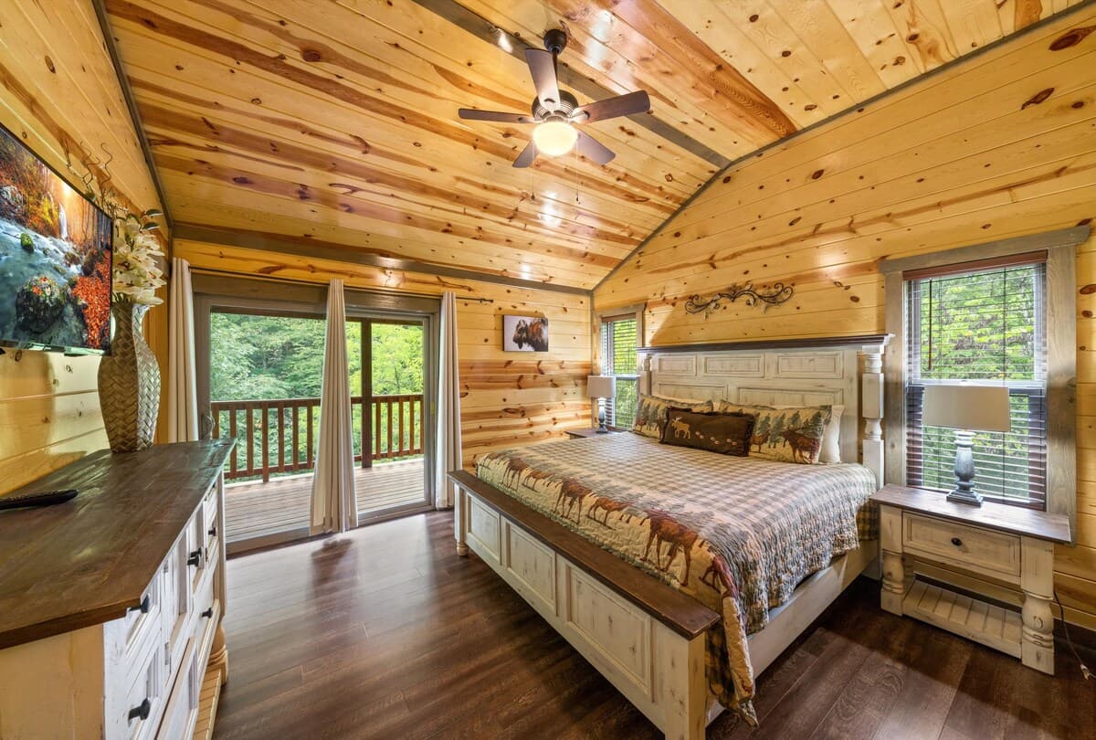 Escape to this cozy bedroom with a king-size bed, private bathroom, closet, dresser, and TV. Step onto the deck to enjoy stunning views and fresh mountain air. Designed for comfort and relaxation, this serene retreat is perfect after a long day.